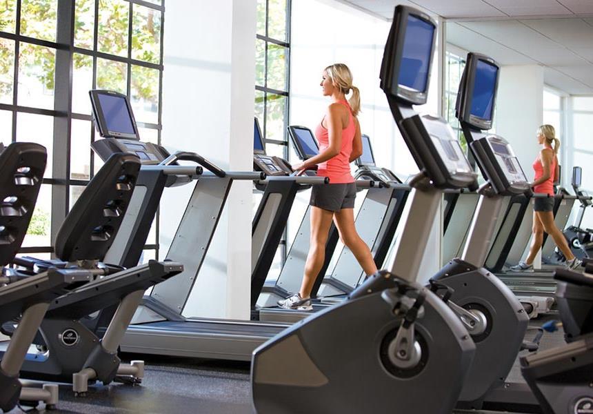 Woman using treadmill in fitness center.