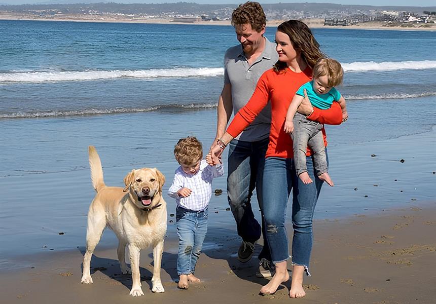 Family at the beach with golden lab.