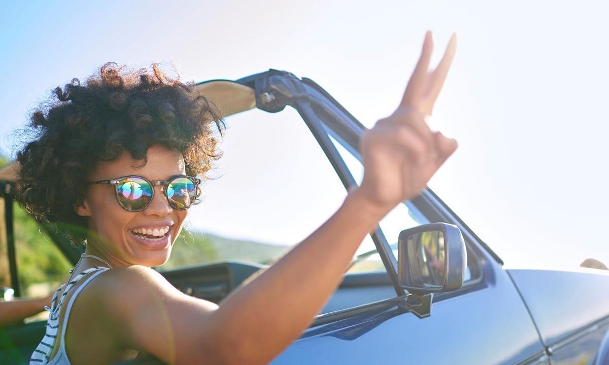 Woman in car giving peace sign