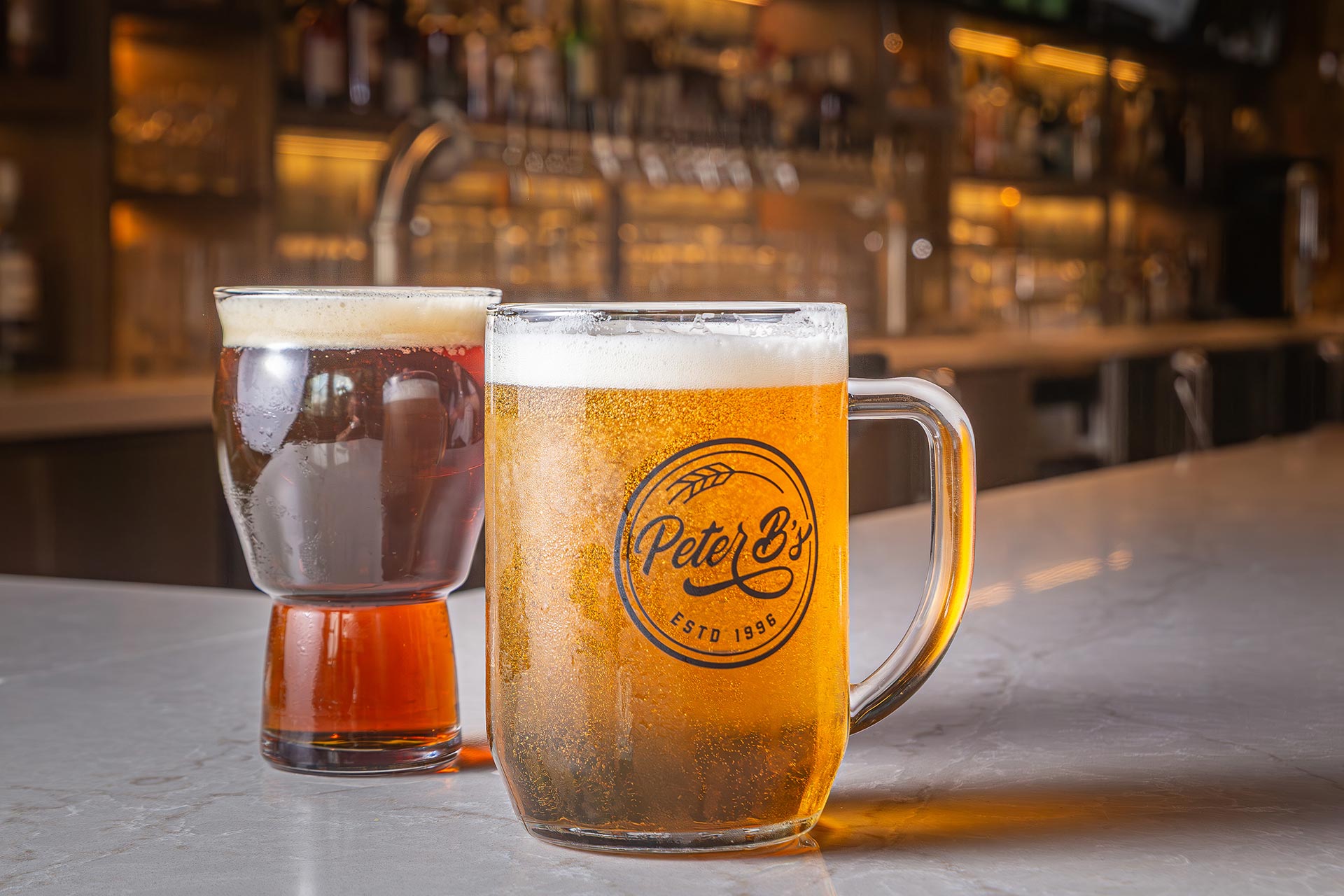 Two beers on the bar top.
