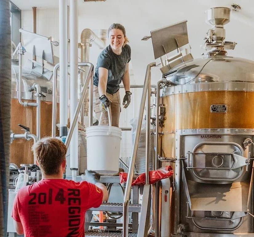 brewers checking beer in silo
