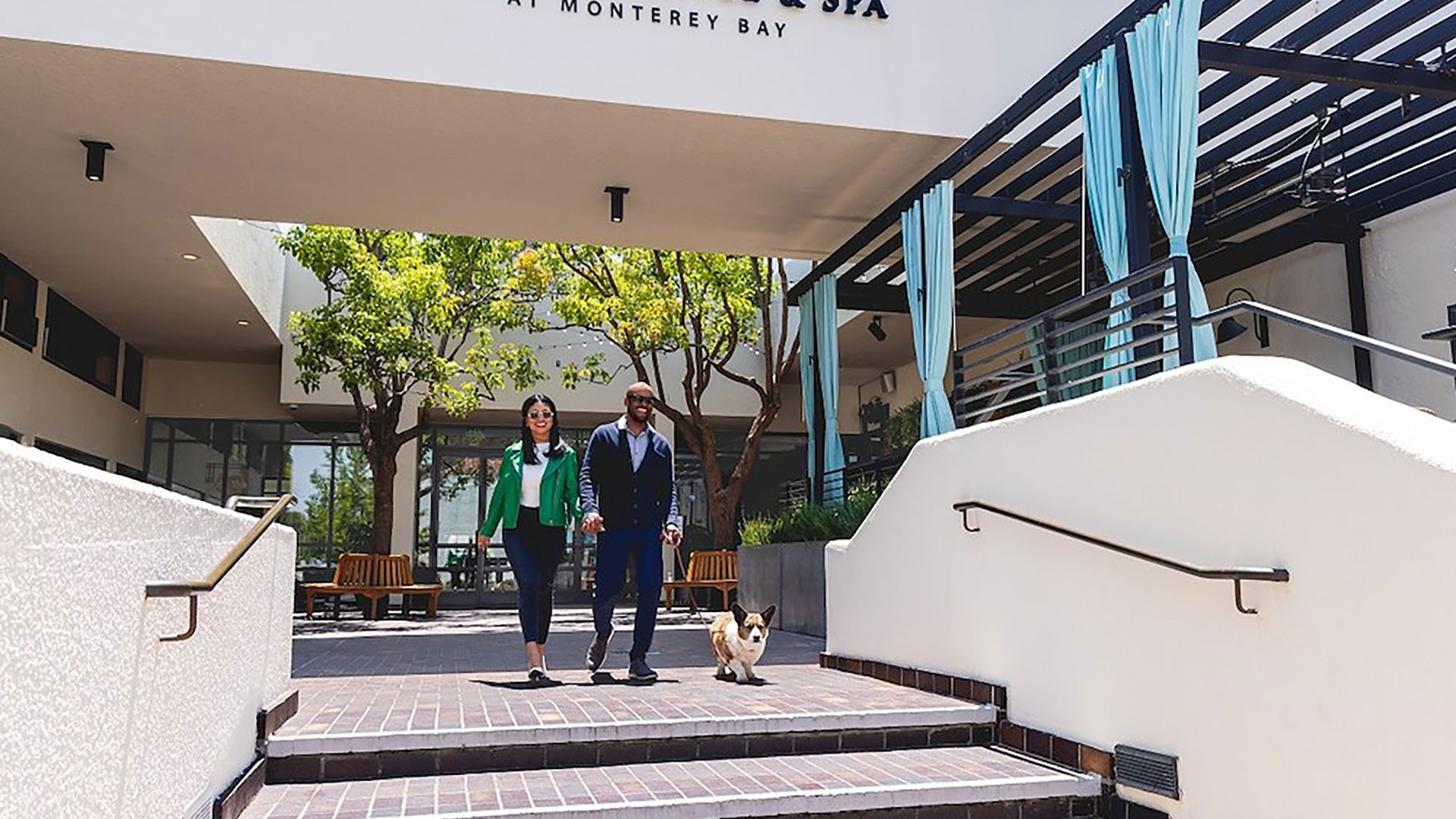 corgi with owners at front entrance